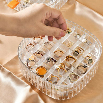 Transparent jewelry organizer box with various jewelry pieces inside