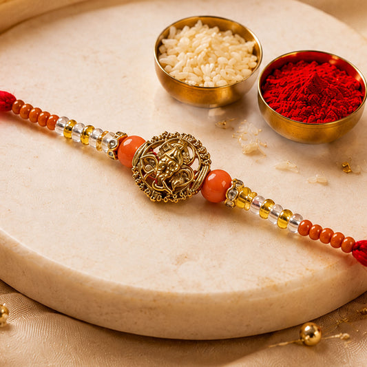 Lord Ganesha Golden Devotional Rakhi with Orange Beads and Crystal Highlights