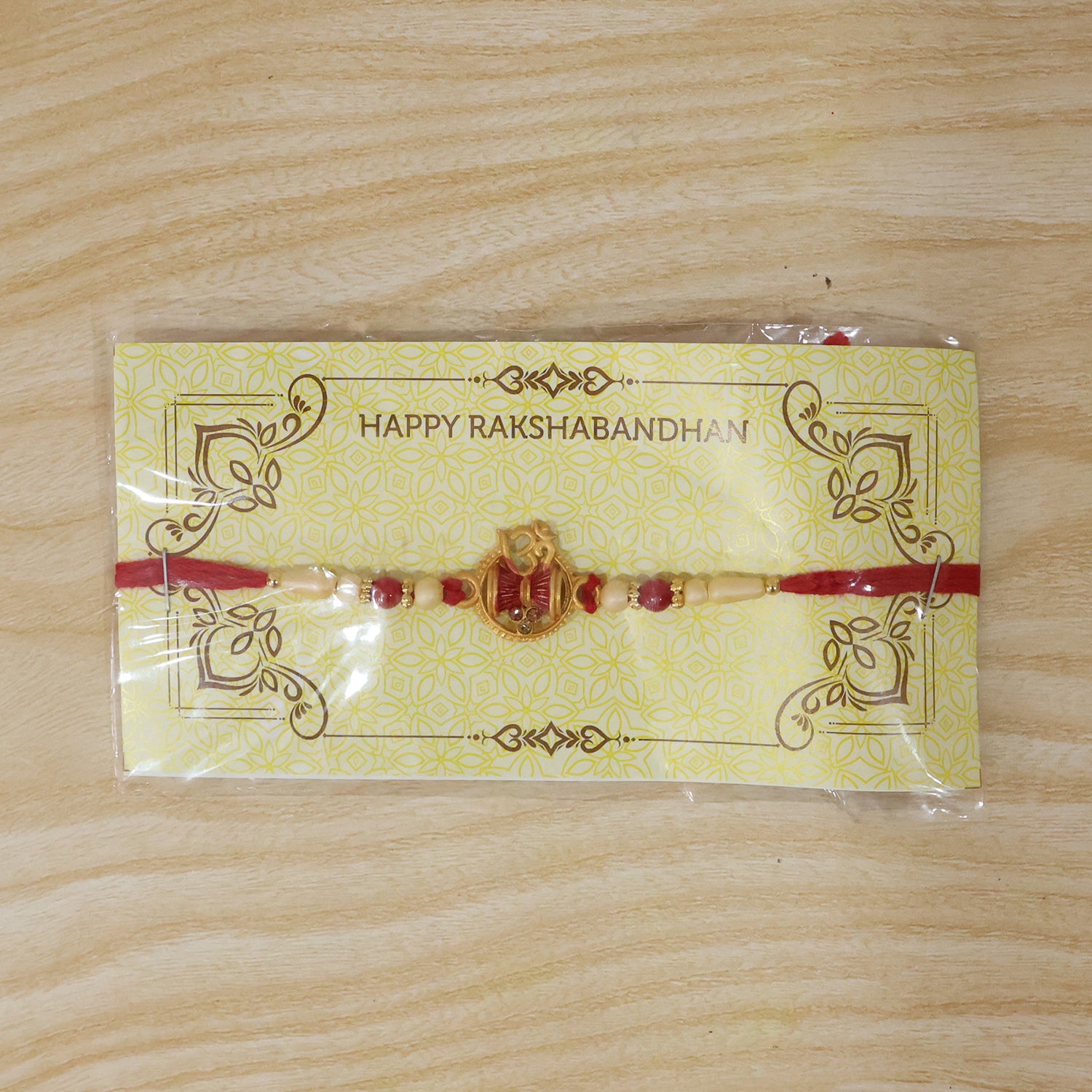 Golden Damru Om Rakhi for Boys with Red and White Beads