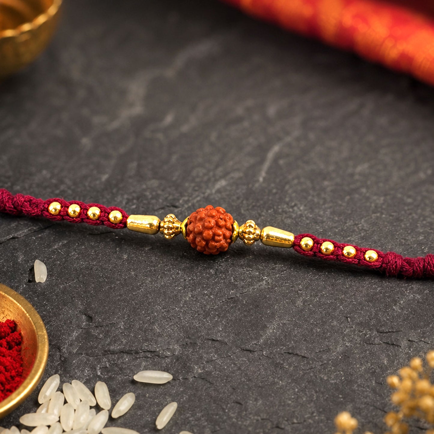 Red Braided Rakhi with a Rudraksha Bead and Wooden Bead Accents