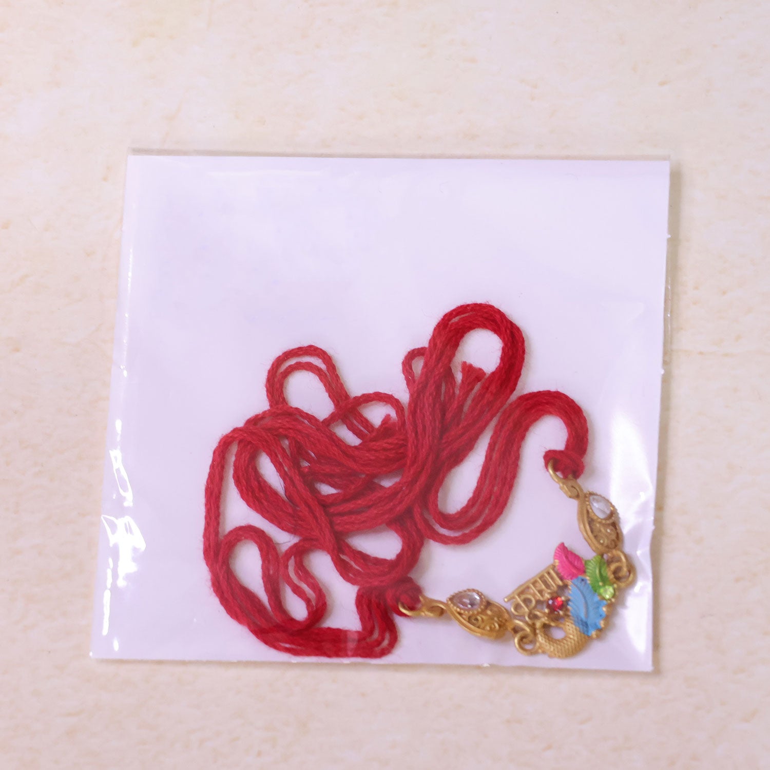 Designer Rakhi with Decorative Floral Medallion, gold trims and chain look for Gift