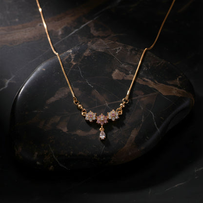 Closeup of elegant floral stone necklace with gold finish and teardrop pendant