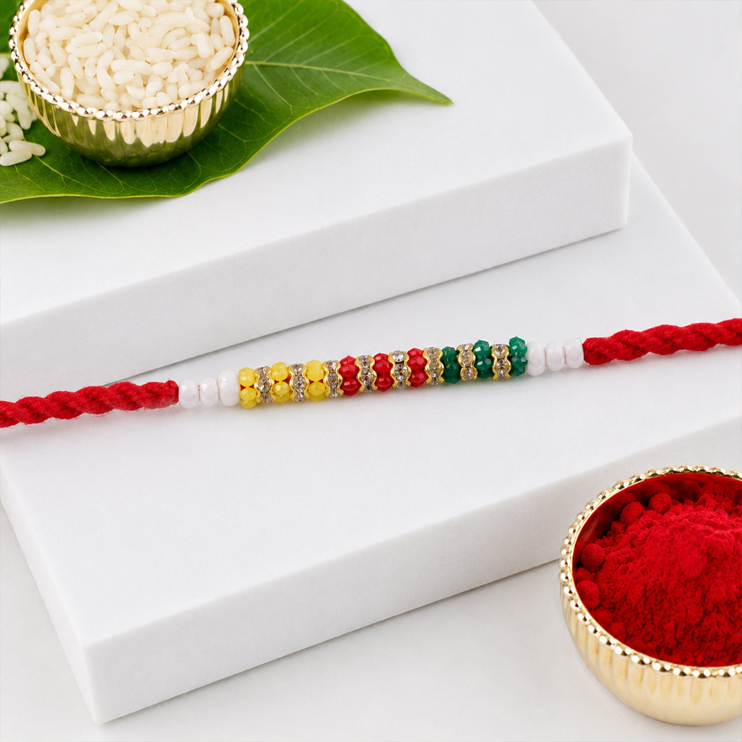 Red Braided Rakhi with Green, Yellow and White Bead Pendant Row