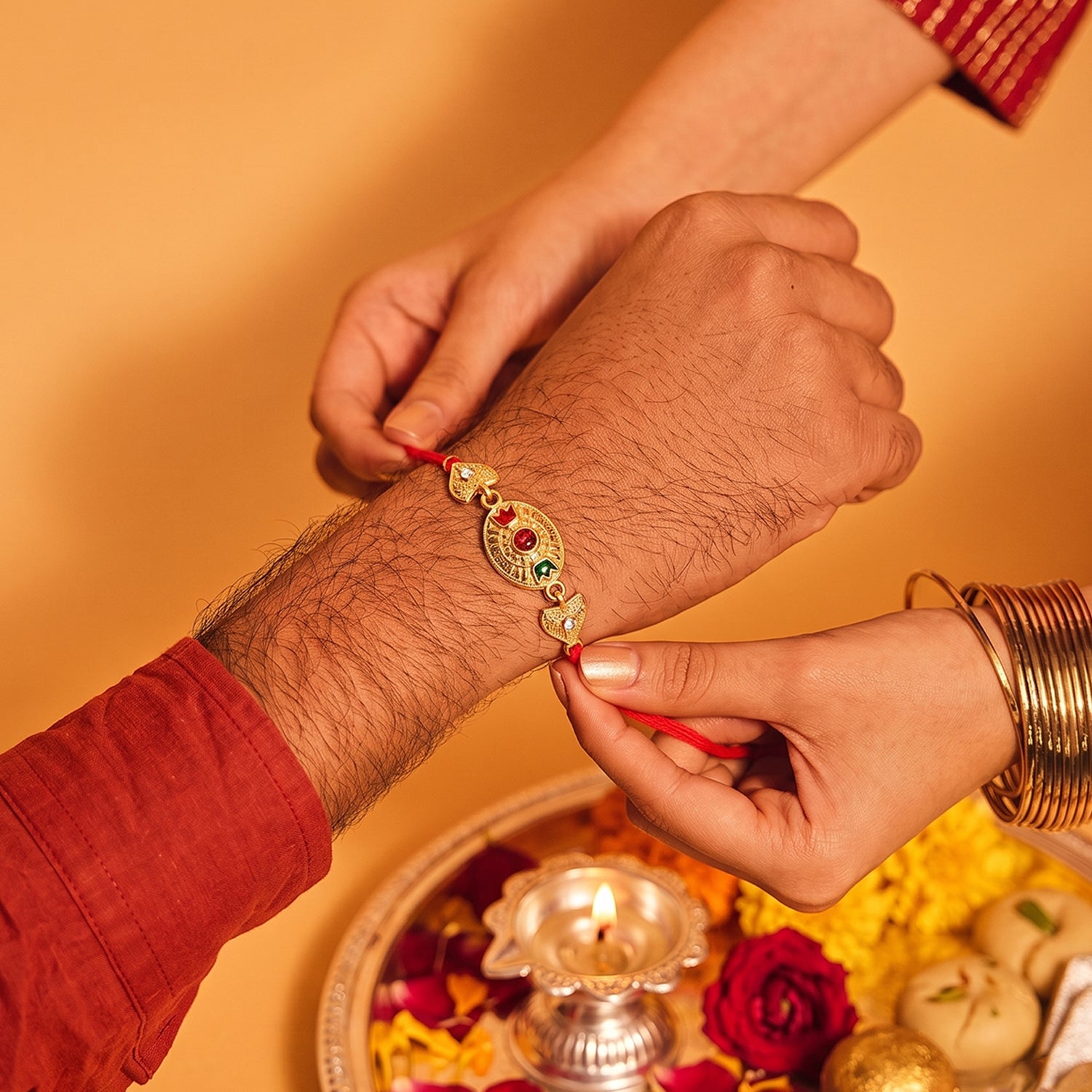 Sacred Bond Designer Gold Rakhi with Ruby & Emerald Stone