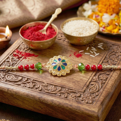 Gold Blue Flower Rakhi with Green Beads and Red Pearl Accents