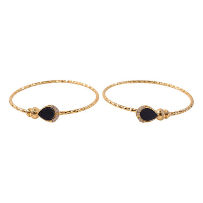 Pair of gold plated black stone bangles on white background