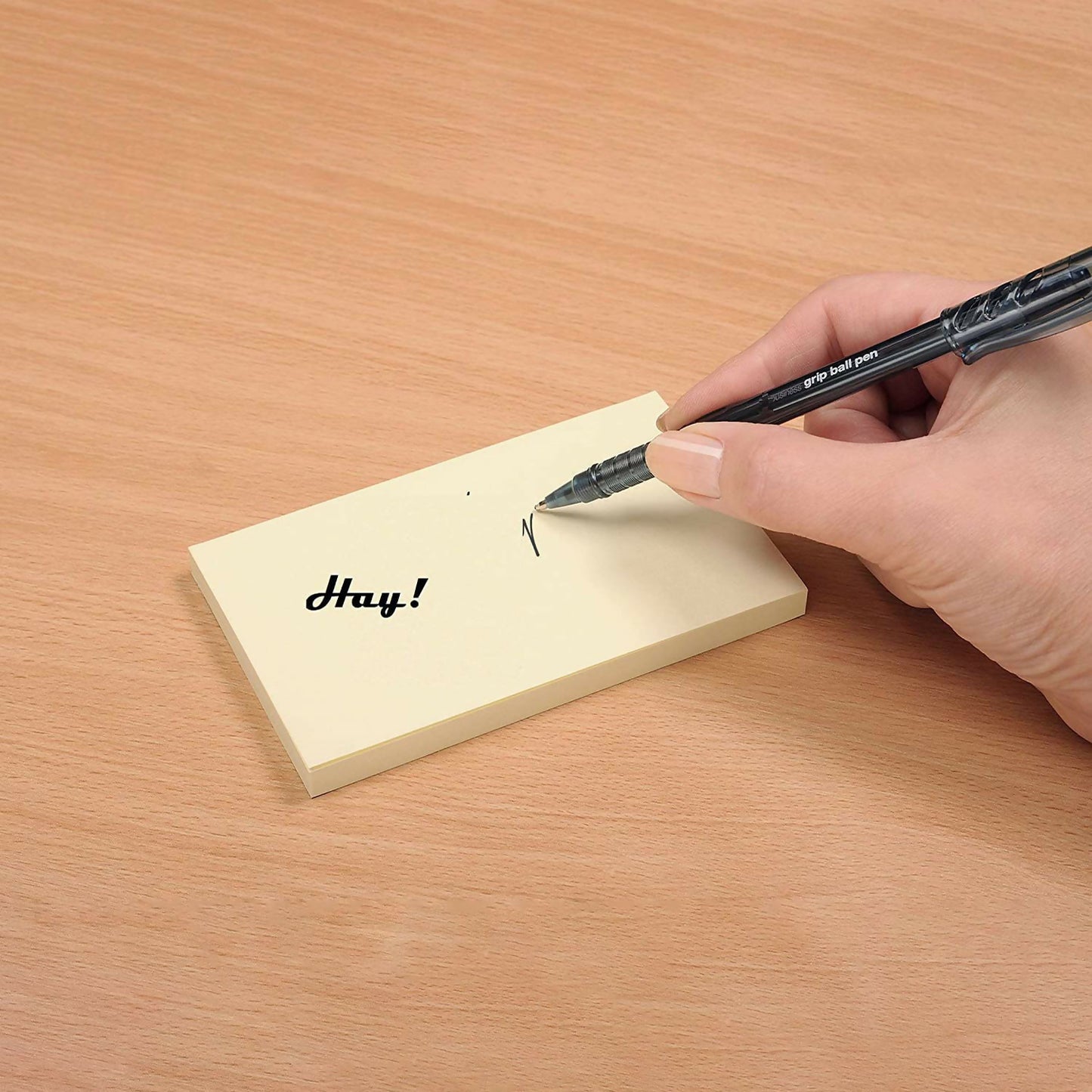 Yellow sticky note pad adhered firmly on laptop surface