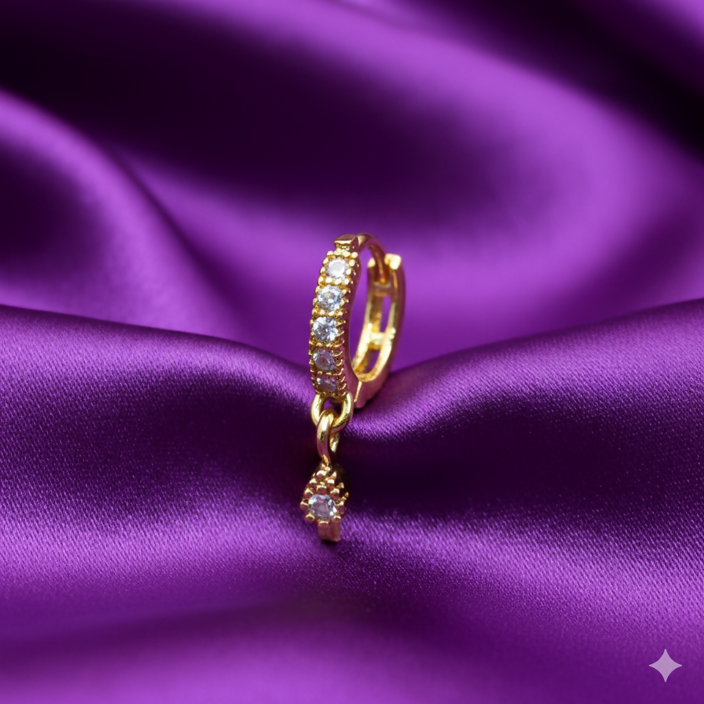 Gold plated nose ring with white cubic zirconia stones and teardrop charm on white background