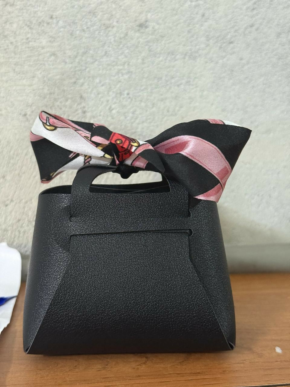 Black mini coin pouch displayed with accessories