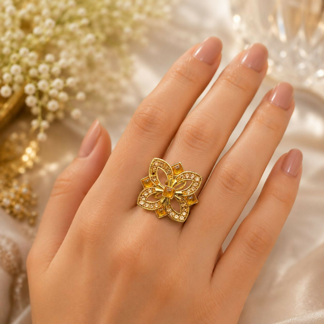 Close-up view of the adjustable gold finish floral crystal ring.