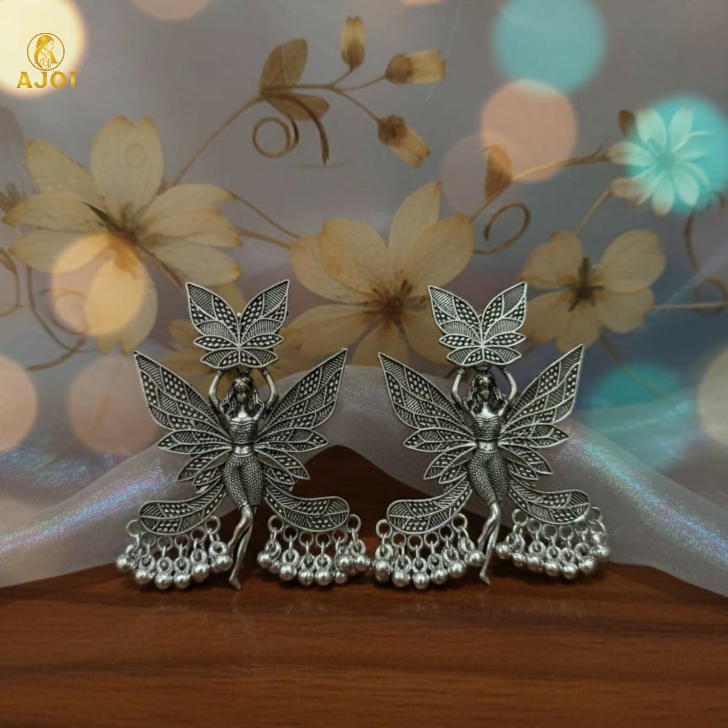 Close-up of oxidized silver fairy wing earring detailing