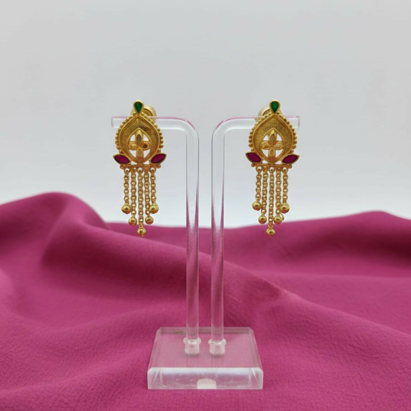Ornate circular studs of gold-plated jhumka earrings with green and blue enamel highlights