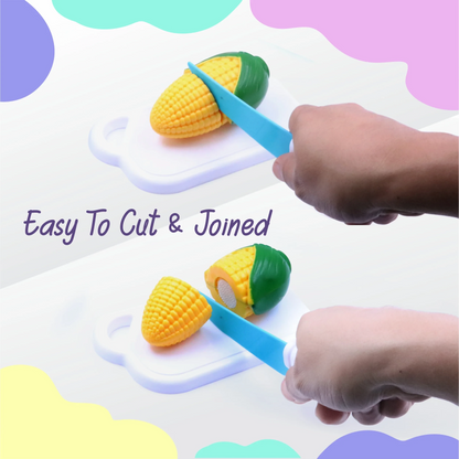Two hands demonstrate cutting a yellow plastic corn toy with a blue knife on a white cutting board.