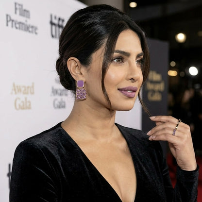 Priyanka Chopra Jonas wearing purple crystal and enamel square drop earrings, looking to her right at an event.