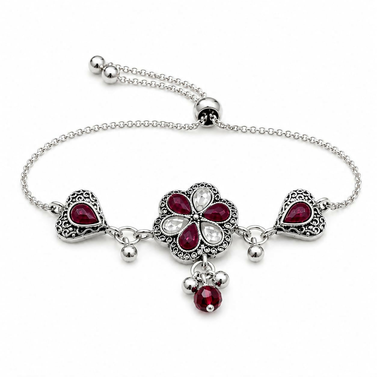 An antique silver adjustable slider bracelet with a central flower, two hearts, ruby-red pear stones, and dangling beads on
