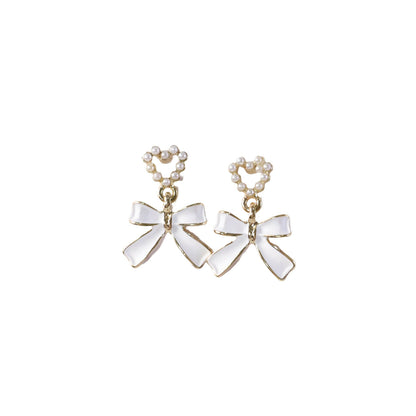Close-up detailing of gold trim on pearl heart earrings
