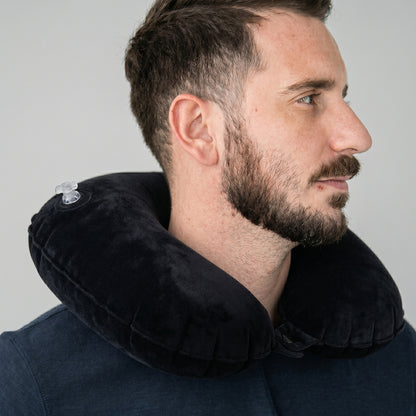 Black inflatable travel pillow in a compact fold for easy packing