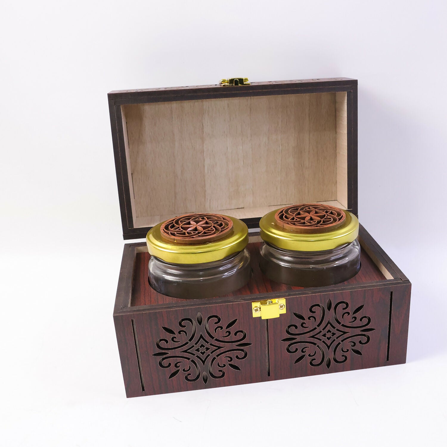 Open handcrafted wooden storage box displaying fresh spices kept in airtight glass jars