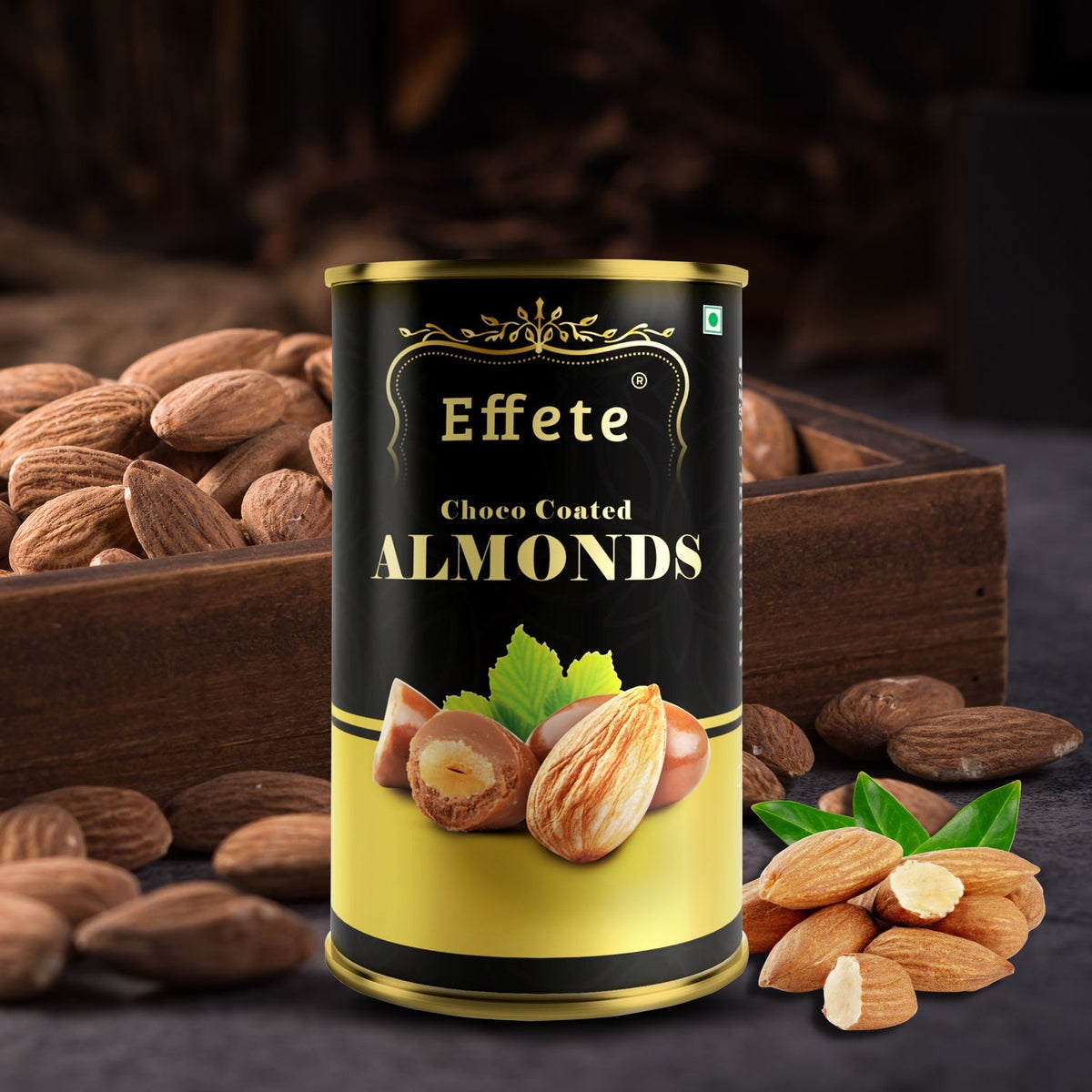 An Effete Choco Coated Almonds can is surrounded by loose almonds and a rustic wooden box.