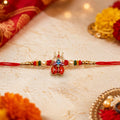 Sacred Trishul & Damru Enamel Rakhi with Pearl & Colorful Bead Accents