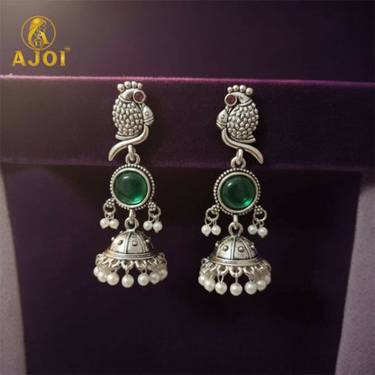 Antique oxidized silver jhumka earrings with intricate design and emerald centerpiece
