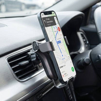 Car phone holder clipped to the air vent with a phone in place