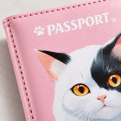 A close-up of the pink passport holder shows a detailed illustration of a black and white cat with bright yellow eyes.