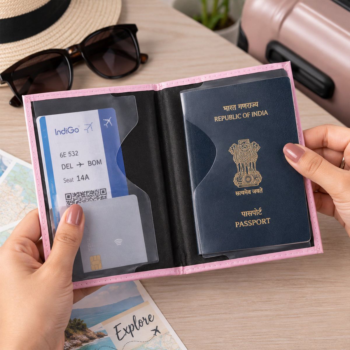 Hands hold the open pink passport holder, displaying a dark blue passport and a boarding pass within its clear pockets.