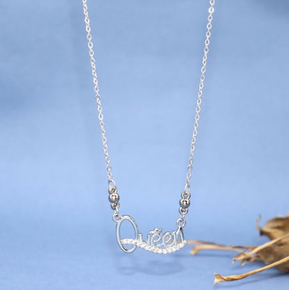 Close-up of Queen script pendant in silver rhodium with glittering Cubic Zirconia stones