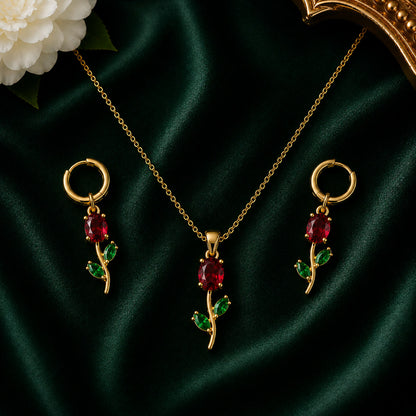 Ruby red crystal floral pendant necklace set with matching earrings displayed.