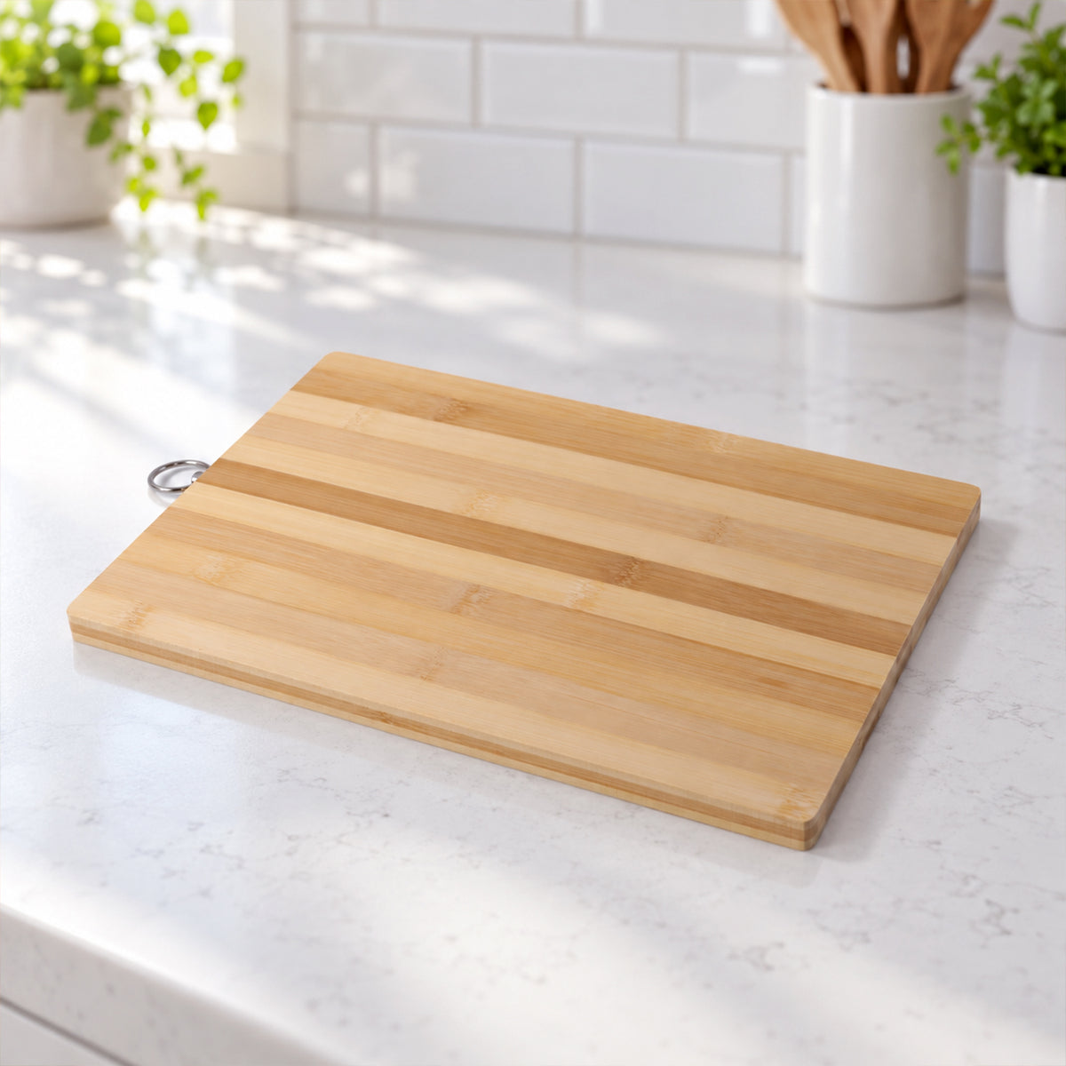 A light-colored bamboo chopping board with a metal ring rests on a speckled white kitchen counter.