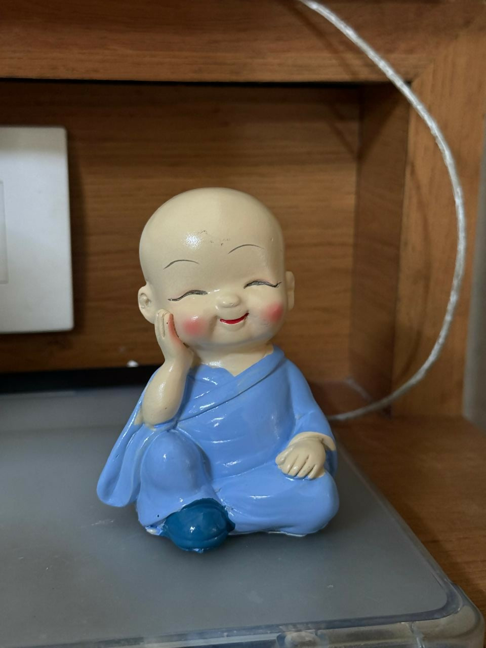 Smiling Monk figurine displayed on a desk