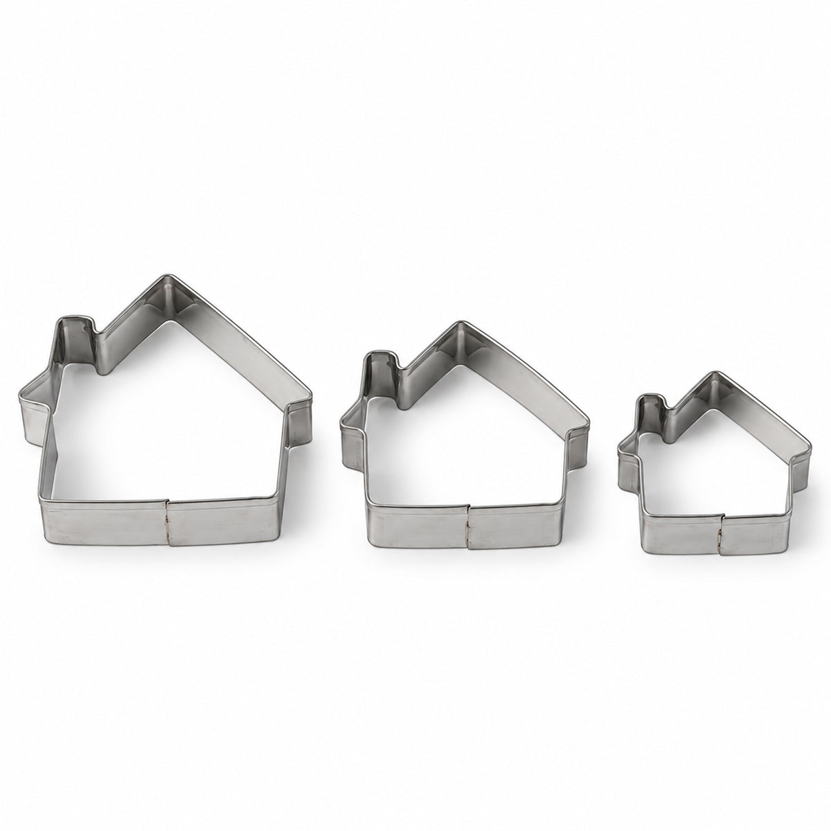 Three silver house-shaped cookie cutters of varying sizes arranged on a plain white background.