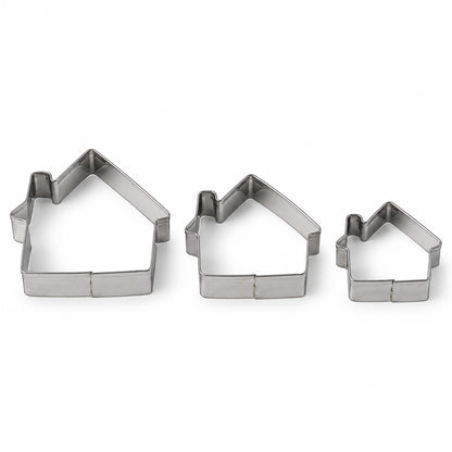 Three silver house-shaped cookie cutters of varying sizes arranged on a plain white background.