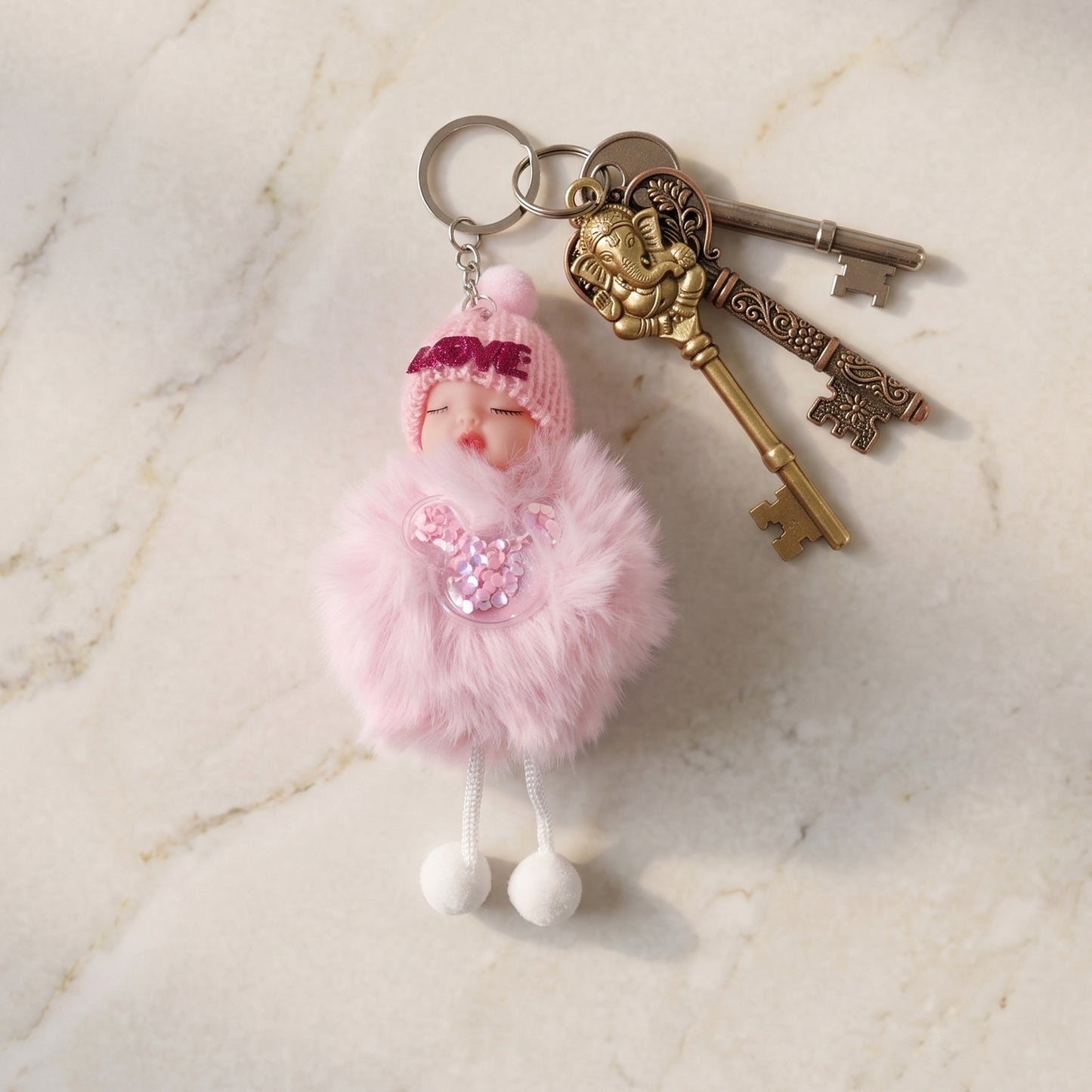 Doll plush keychain with sleeping face and fur ball close-up