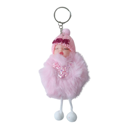 Hand holding the cute doll plush keychain with soft fur ball