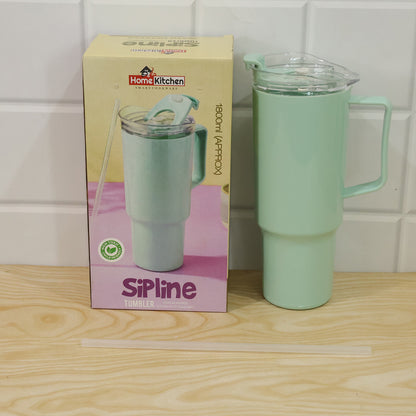 A mint green tumbler with a straw and handle next to its product box, on a wooden surface.