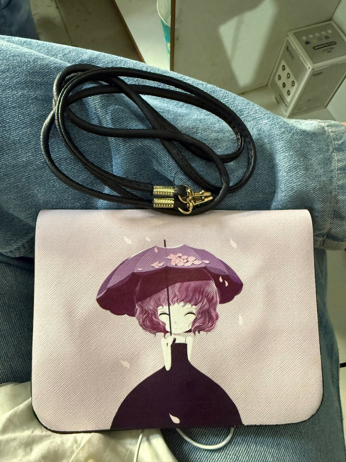 Purple cartoon print sling bag worn crossbody by a model