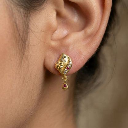 Close-up of intricate flower details in gold plated earrings for women