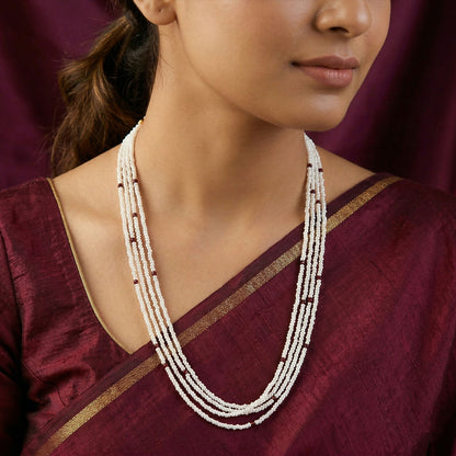 Close-up of handmade white mala necklace beads with maroon details