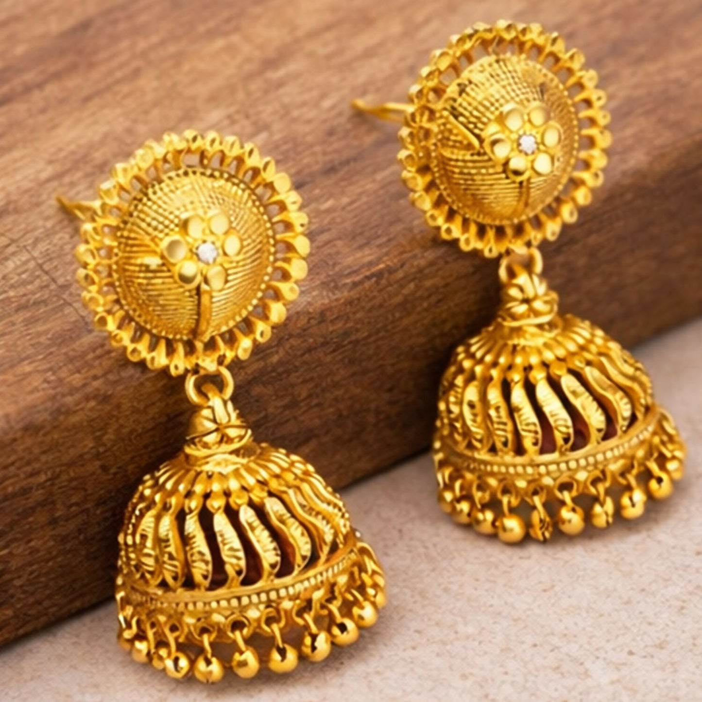 Side view of traditional ethnic gold plated jhumka earrings with intricate detailing