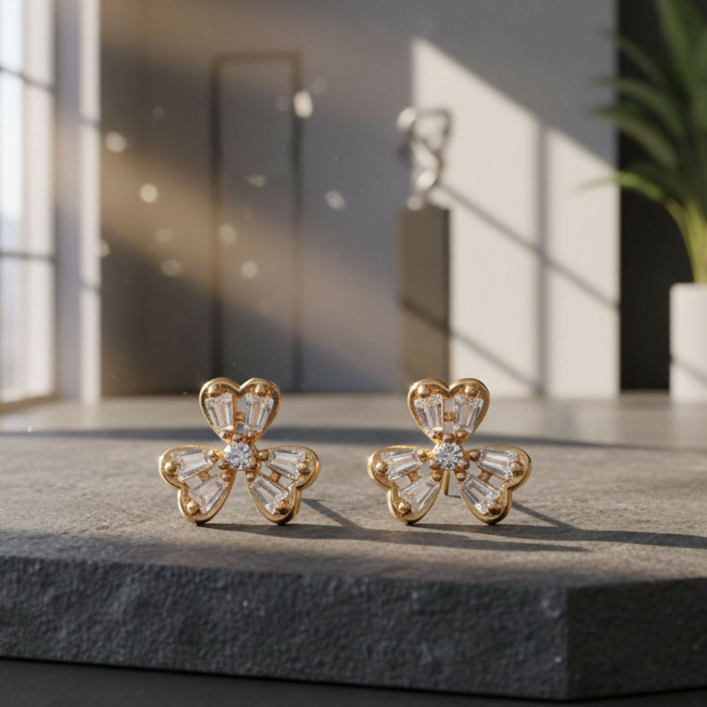 Floral CZ stud earrings with gold finish showcasing delicate four-petal design
