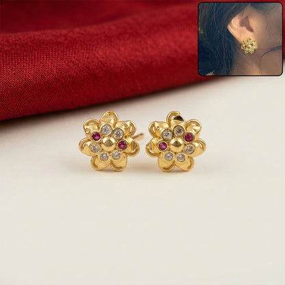 Close-up of elegant gold flower stud earrings with crystal detailing