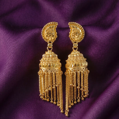 Close-up of gold-plated jhumka earrings with intricate chain detail