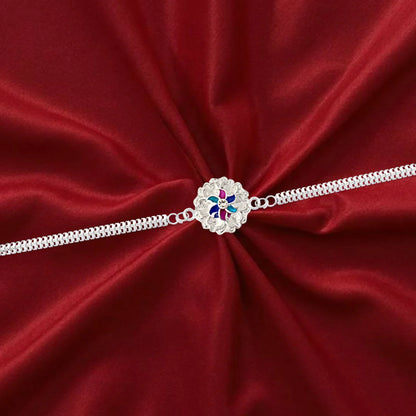 Silver Floral Rakhi displayed on a wrist, showcasing its dual chain.
