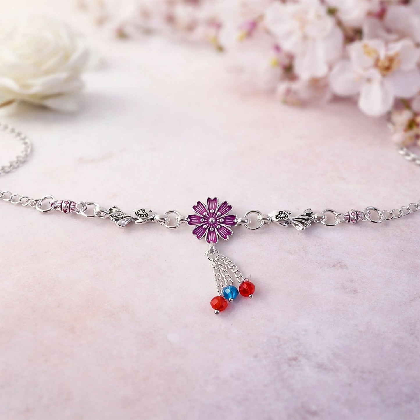 Detail of silver flower charm bracelet with colorful dangling beads