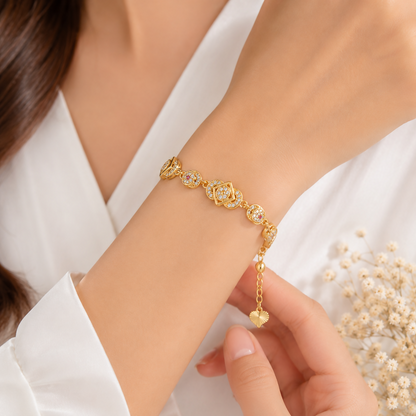 A woman's wrist adorned with a gold-plated bracelet, showcasing its delicate design and sparkling cubic zirconia details.