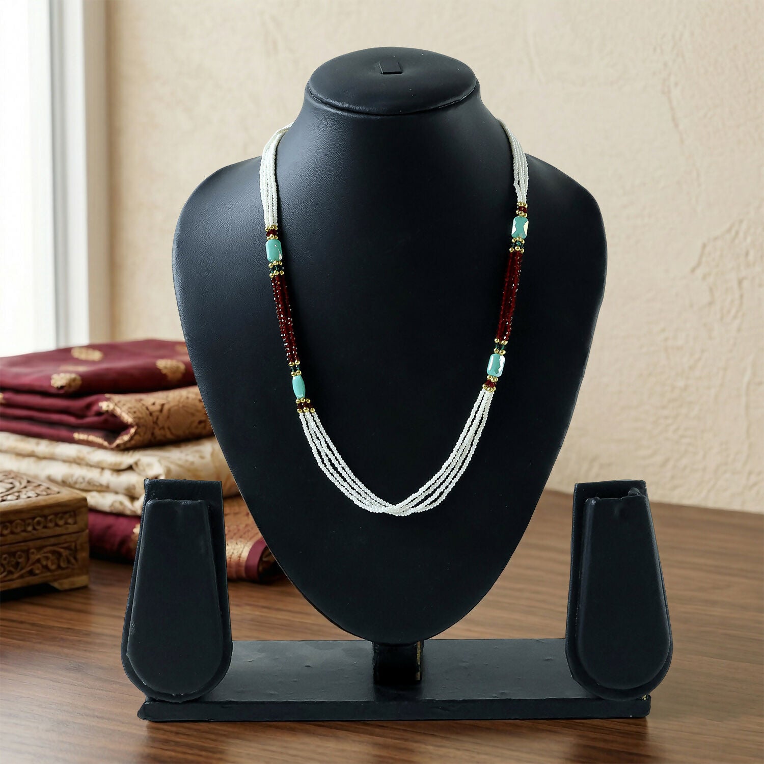 Layered pearl mala necklace showing red and turquoise accents