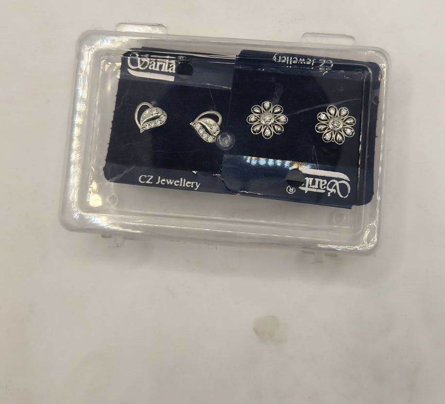 Silver heart and flower stud earrings displayed in jewelry case ready for gifting