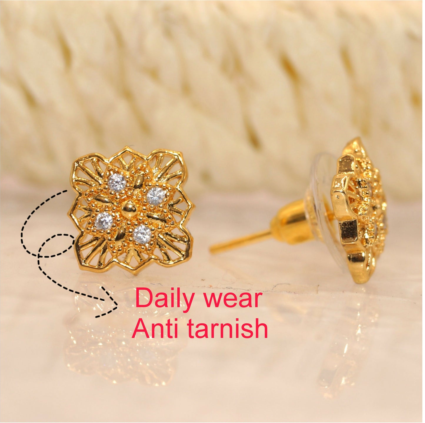 Pair of gold plated filigree floral square stud earrings with push-back closure on a white background